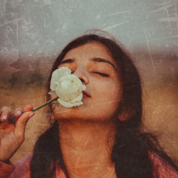 A faded and damaged old photograph showcasing typical aging signs like scratches, tears, and discoloration